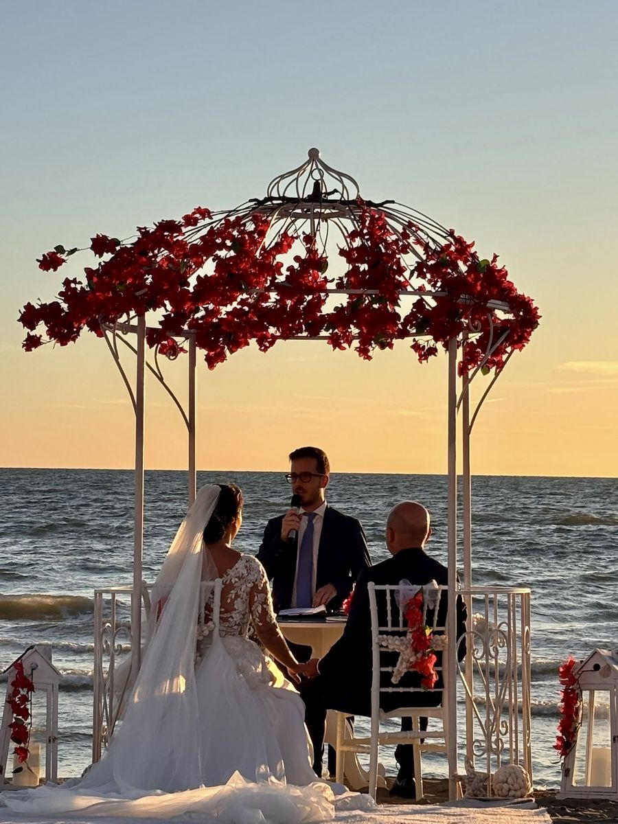 Cerimonia al tramonto sulla spiaggia, sotto il gazebo fiorito